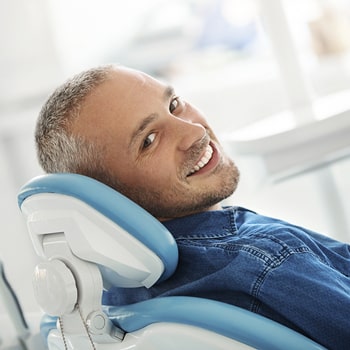 A smiling man in a dentist's chair.