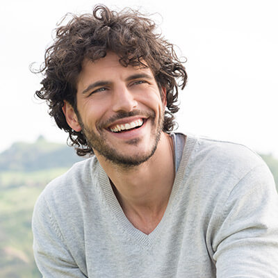 A smiling man in a gray sweater.
