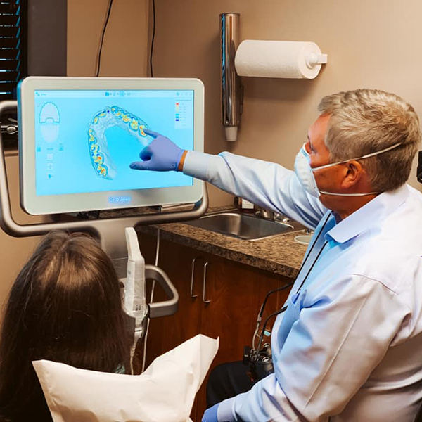 Dr.Lakota pointing to a monitor screen while a patient looks on