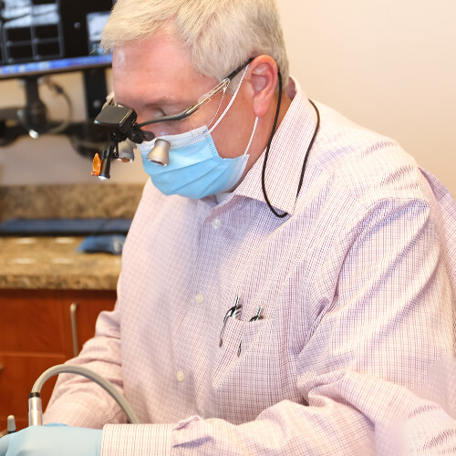 Dr.Lakota performing a procedure on a patient lying on a dental chair