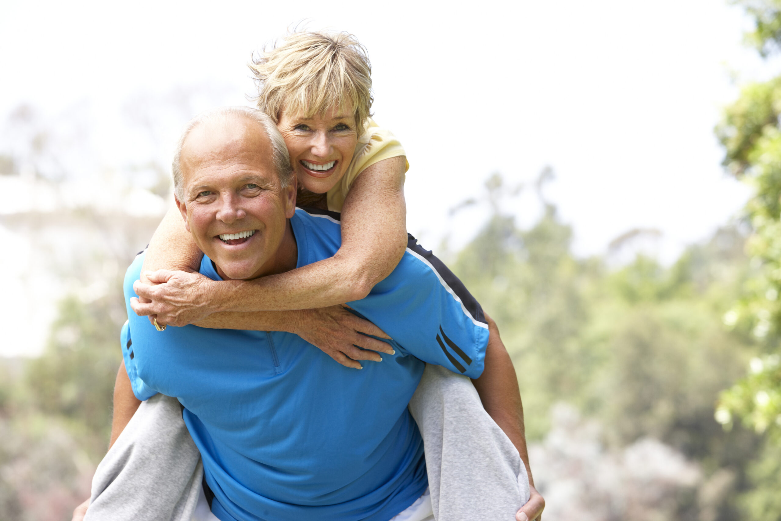 Smiling senior couple benefits from restorative dentistry.